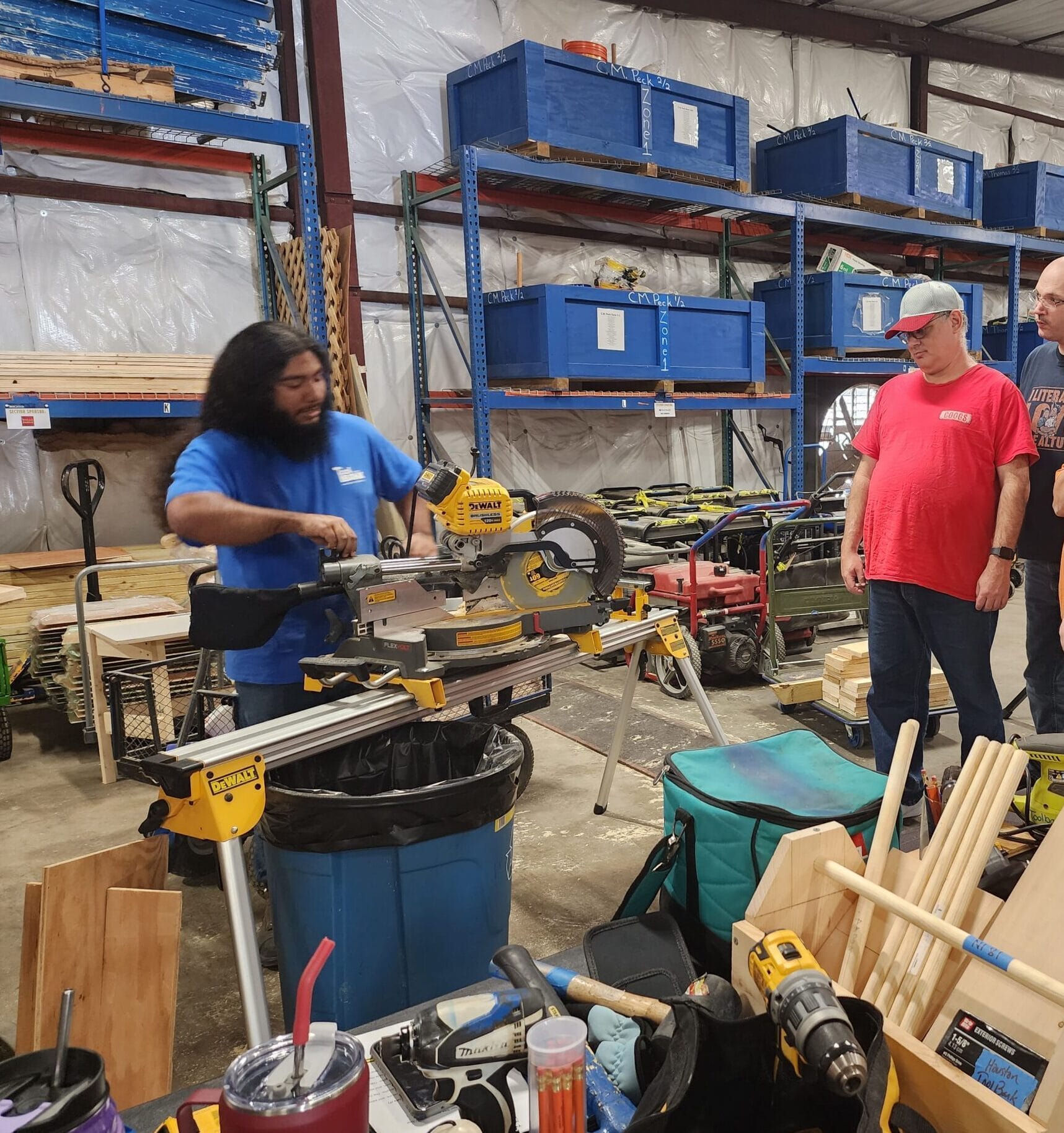 A Houston ToolBank staff member showing volunteers how to use the table saw