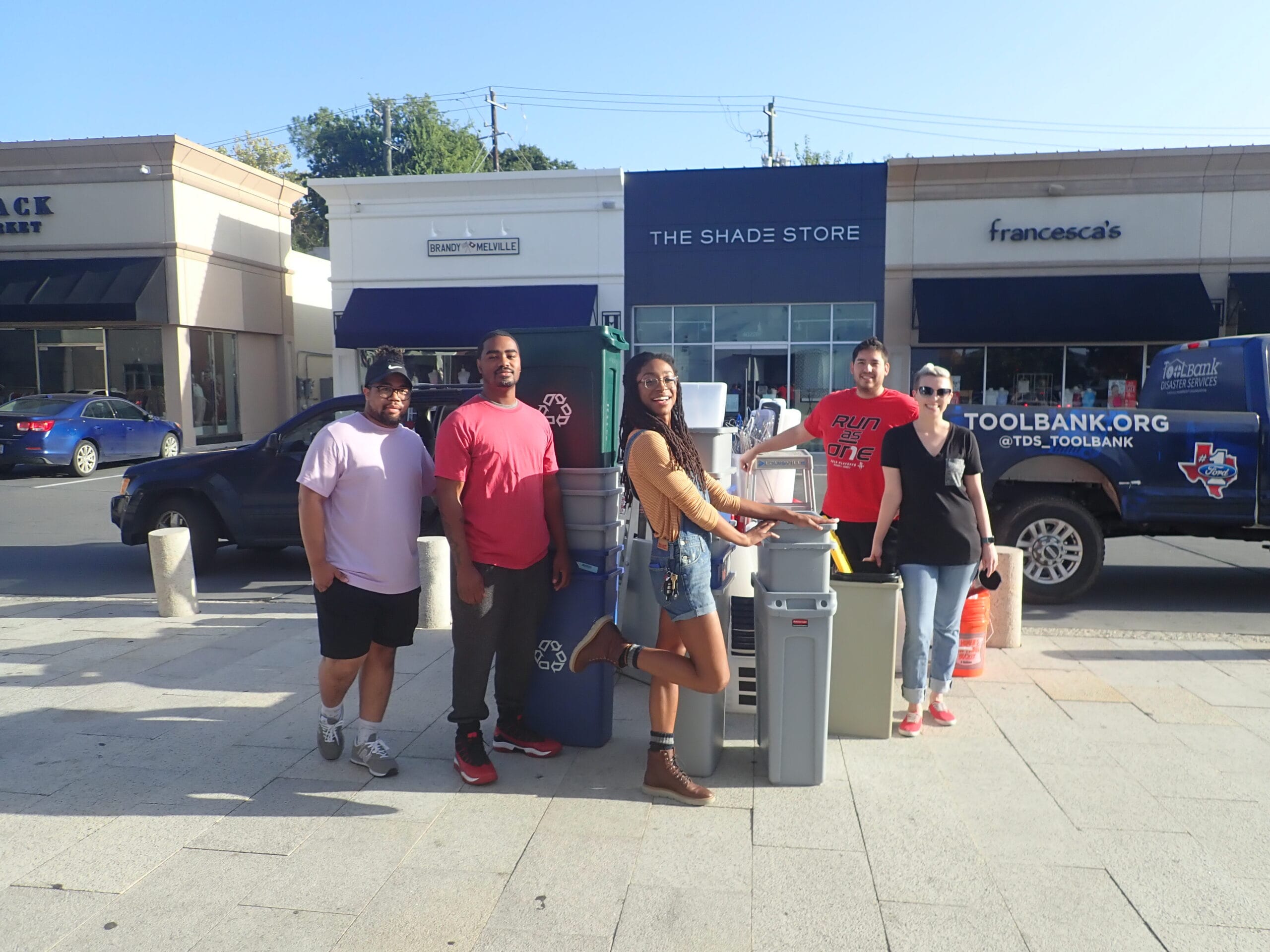 Houston ToolBank volunteers standing next to recycling containers