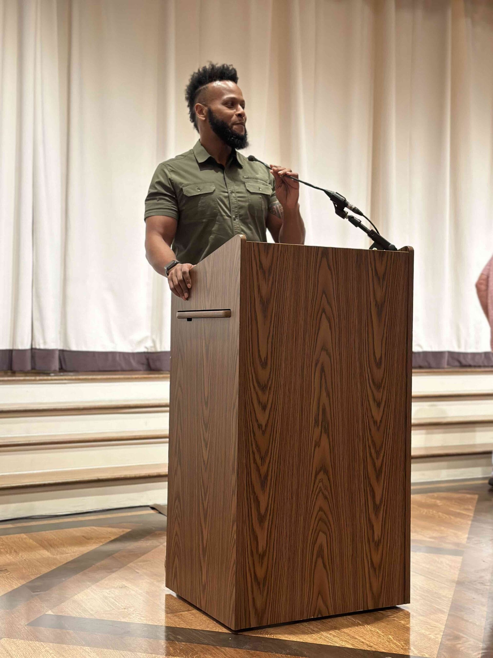 A man standing up at a podium about to speak at a Houston ToolBank event