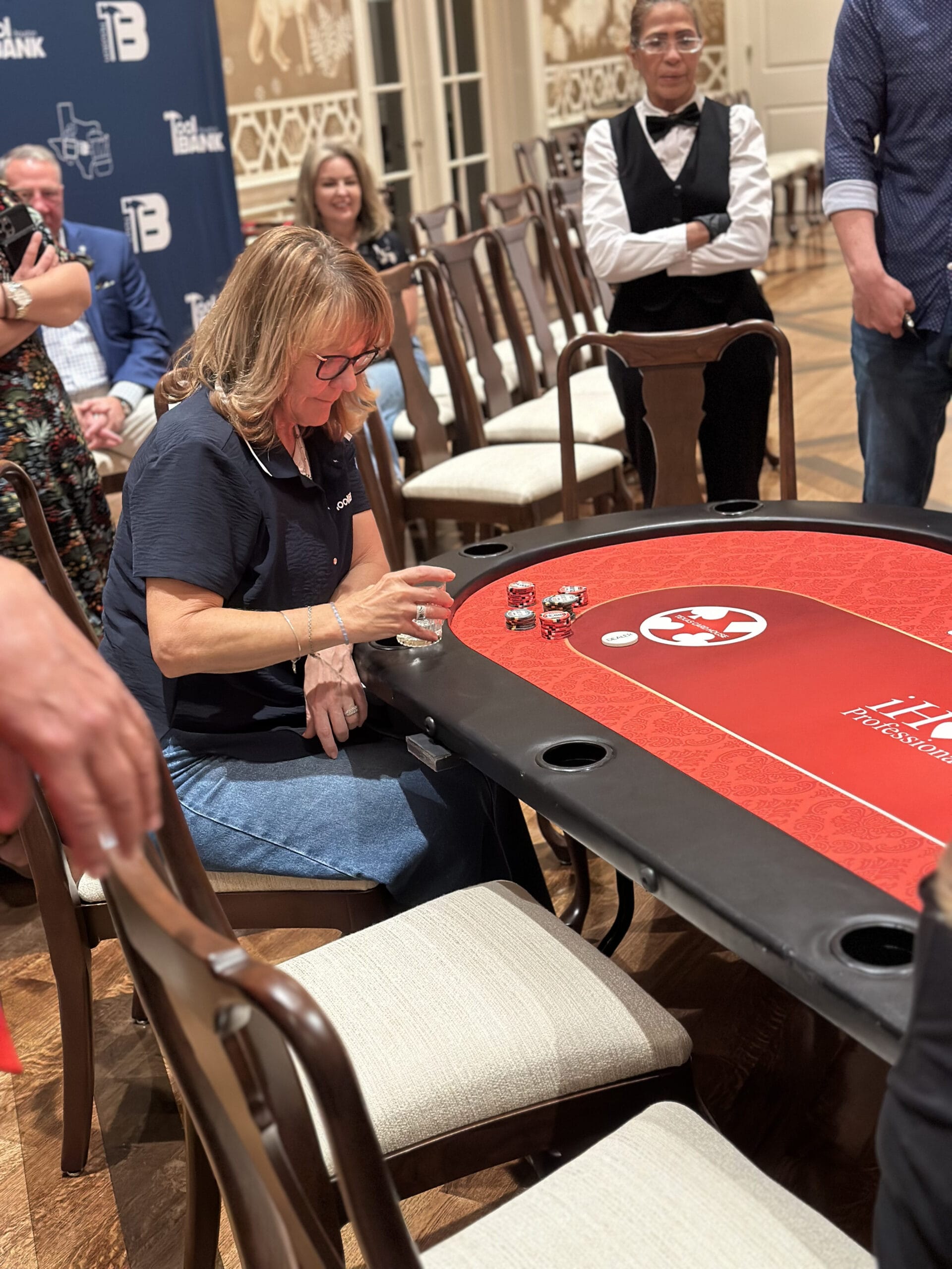 A woman looking at her poker chips at a Houston Toolbank charity event