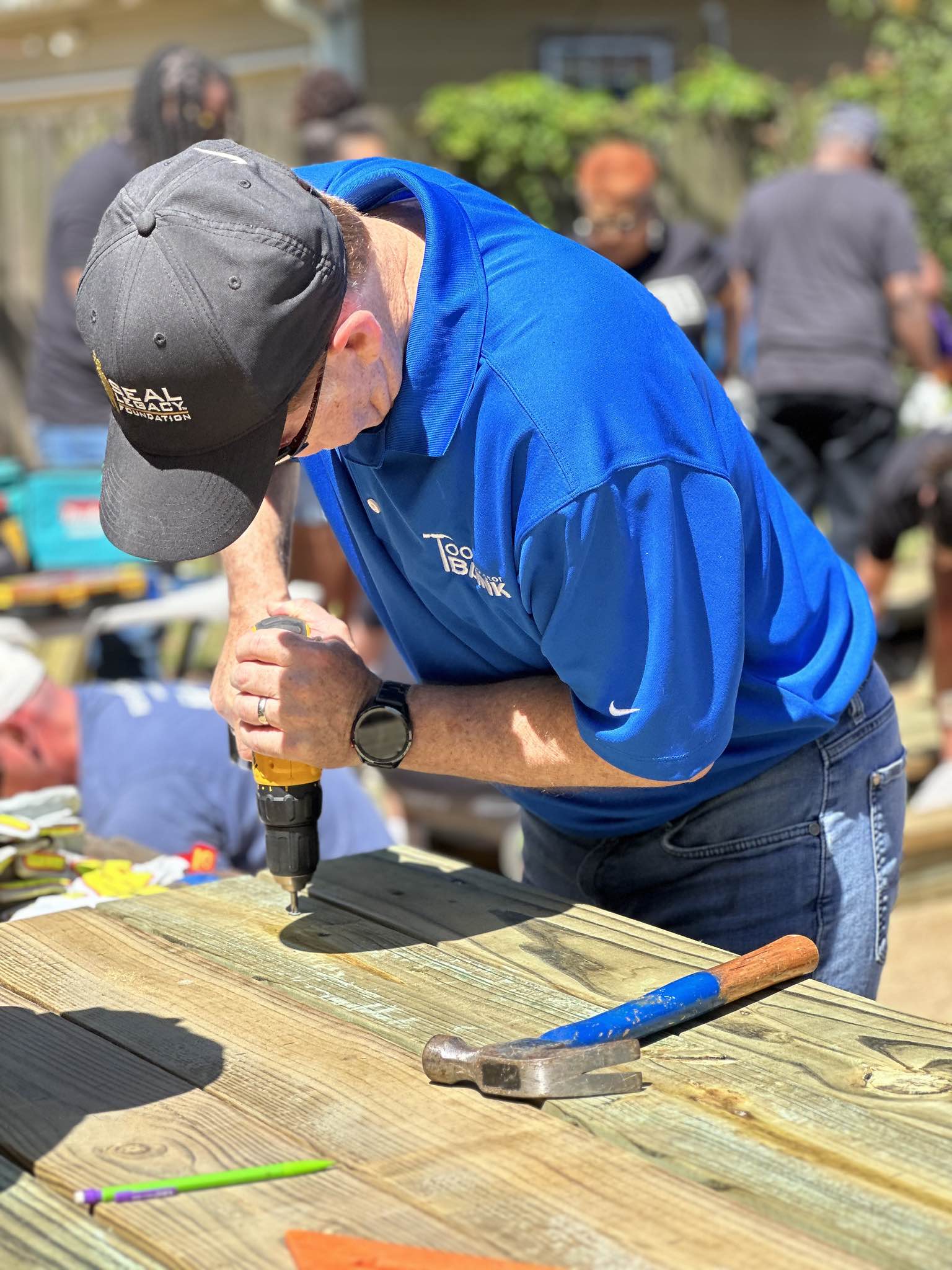 A Houston ToolBank volunteer in a blue shirt drilling down into a table