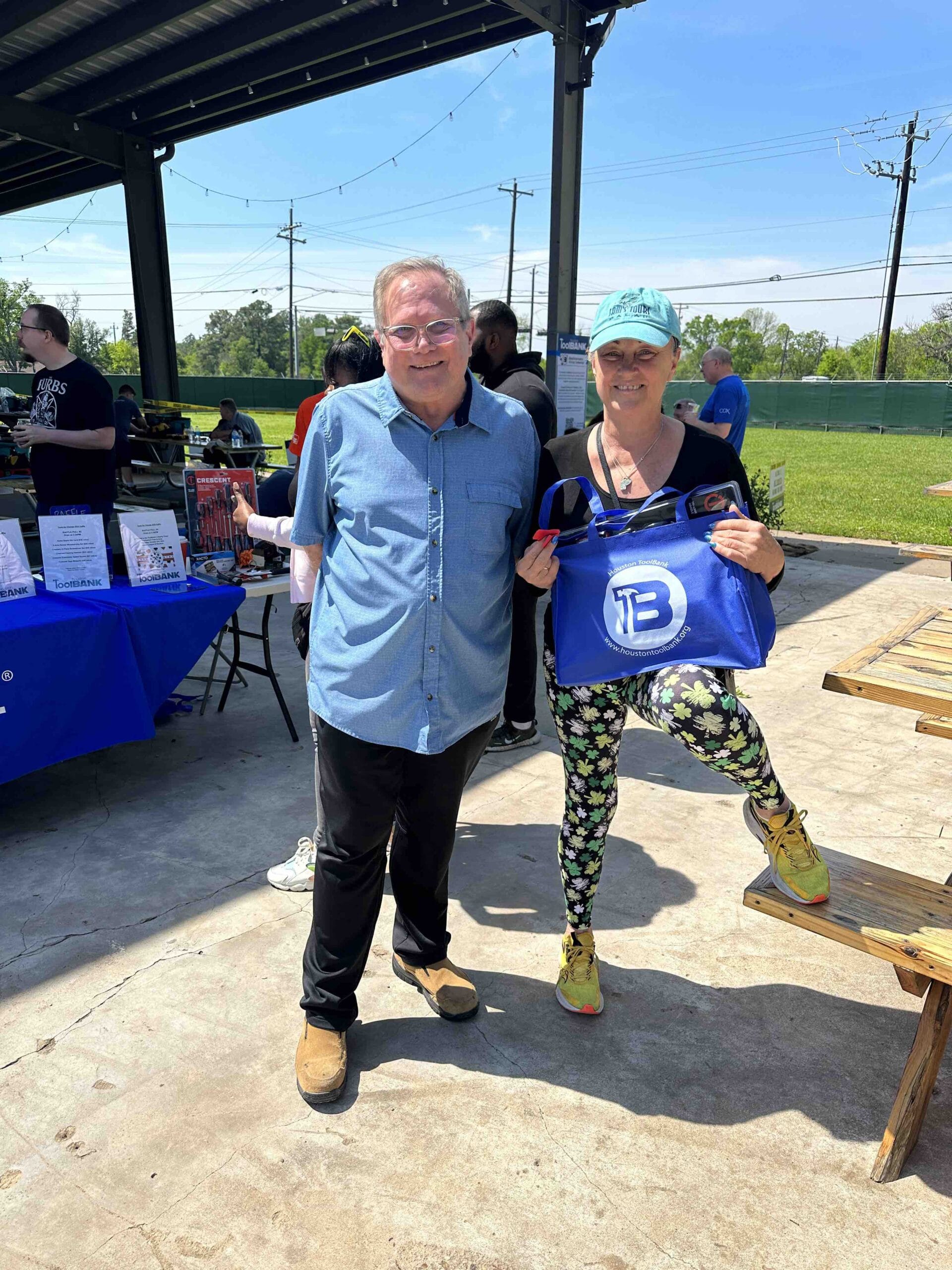 Houston ToolBank volunteers holding a ToolBank tote bag