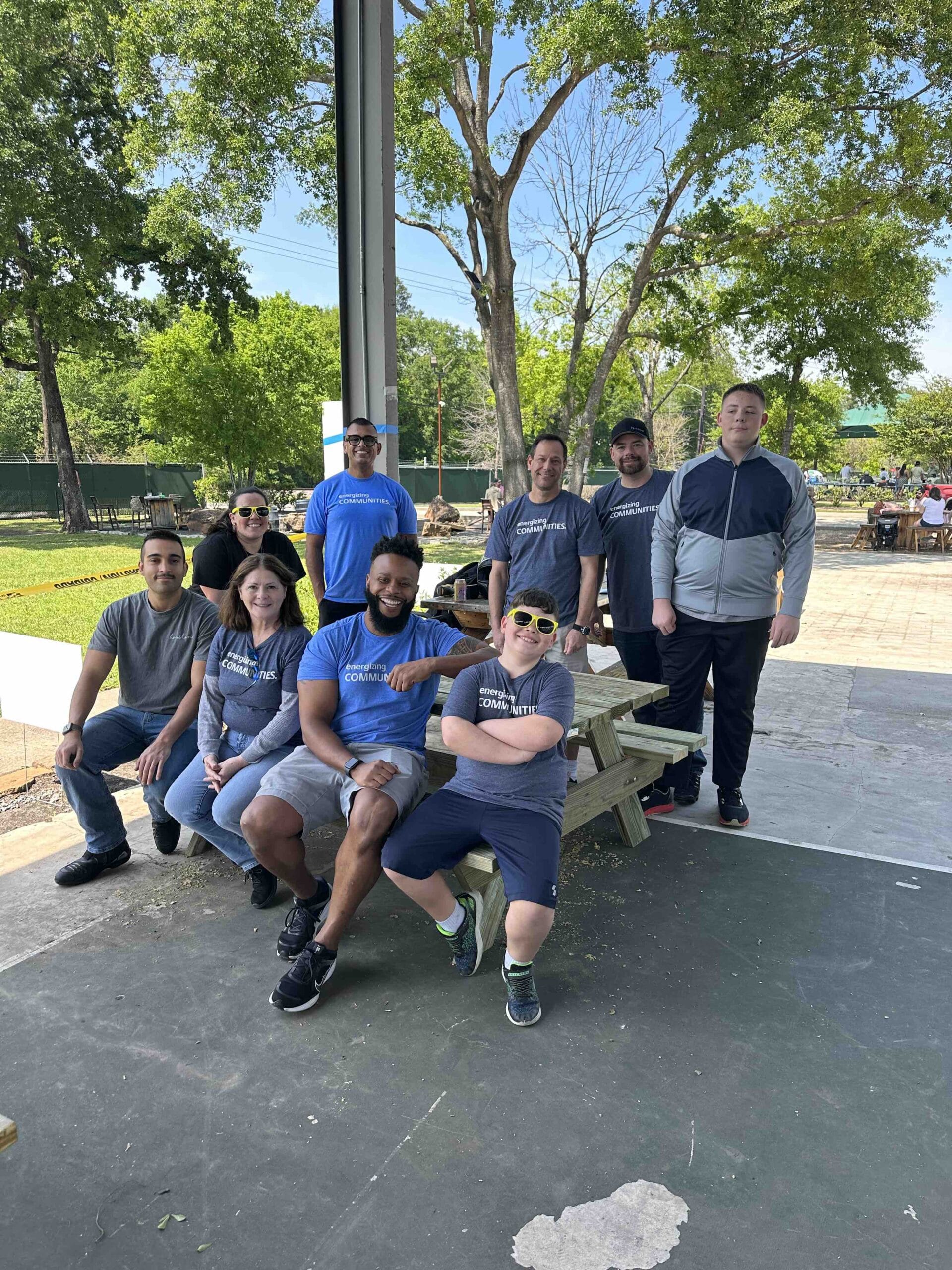 A volunteer group sitting on a wooden lunch table they built at the Houston Toolbank