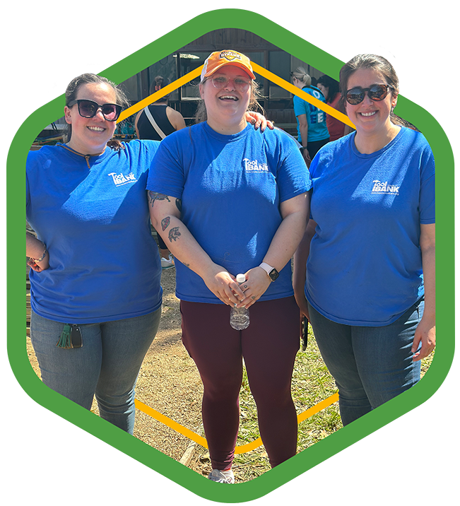 A green badge of three women standing next to each other smiling